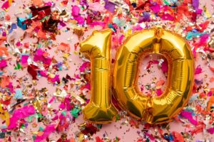 בלוןנים בצורת המספר 10 על רקע קונפטי.
